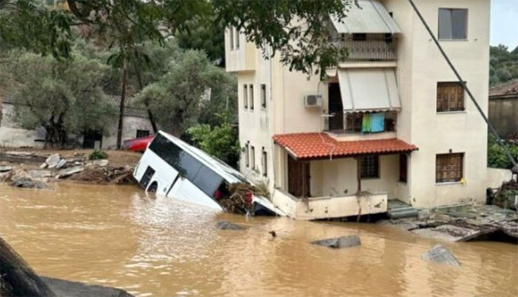 Στις φωτογραφίες, όπως μεταδίδει η ΕΡΤ, απεικονίζεται μία τριώροφη κατοικία να έχει πάρει κλίση και να «στηρίζεται» σε ένα τουριστικό λεωφορείο που παρασύρθηκε και βρέθηκε στην αυλή, ενώ ο δρόμος μπροστά από το σπίτι έχει διαλυθεί από τα ορμητικά νερά.