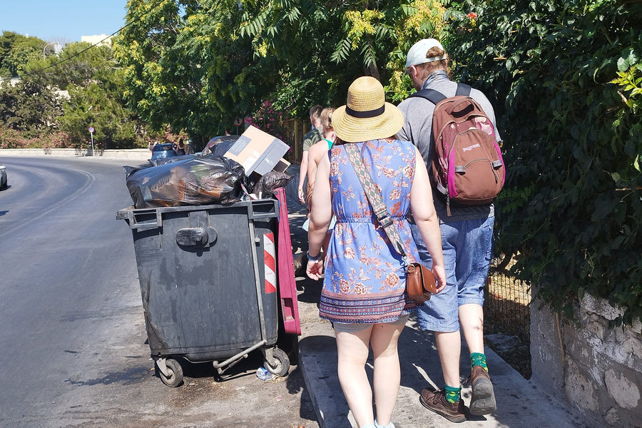 Λίγα μέτρα από το Αρχαιολογικό Μουσείο: Τουρίστες “ακουμπάνε” τους κάδους περπατώντας σε πεζοδρόμιο